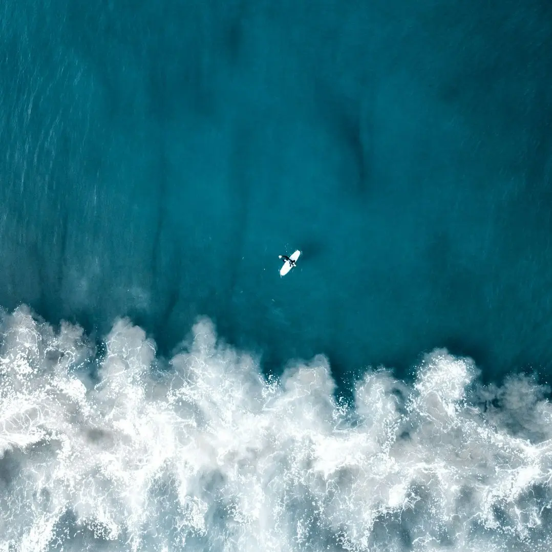 an aerial view of a surfer riding a wave